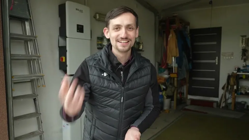 Dawid Jarząbek w garażu klienta przy falowniku hybrydowym SOLAX i magazynie energii, kadr z filmu