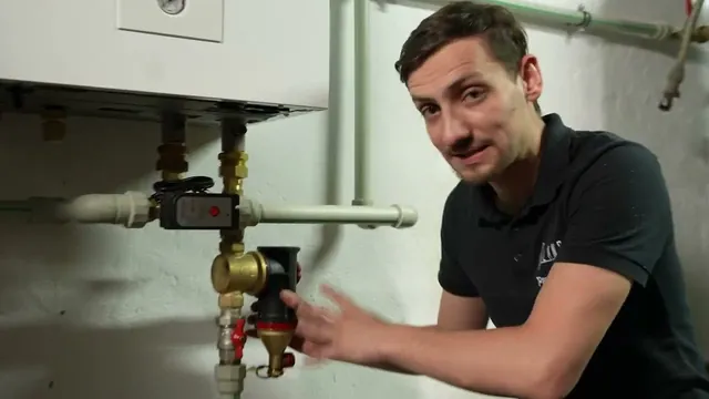 Dawid Jarząbek przy podłączeniach hydraulicznych pompy ciepła w kotłowni