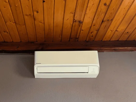 Jednostka wewnętrzna klimatyzatora pod drewnianym sufitem