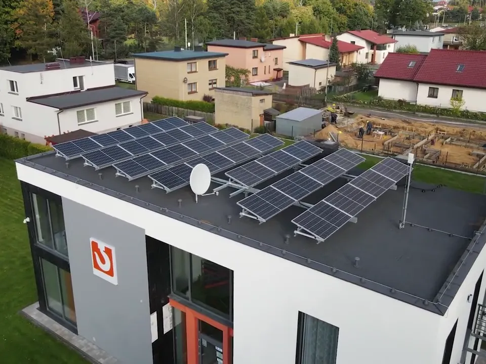 Instalacja fotowoltaiczna 9,99 kWp w Żorach: panele na płaskim dachu nowoczesnego domu, widok z drona