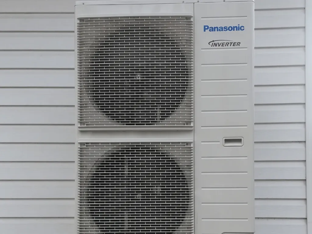 Pompa ciepła, Wodzisław Śląski: Jednostka zewnętrzna Panasonic Inverter (dwa wentylatory) na tle białego sidingu