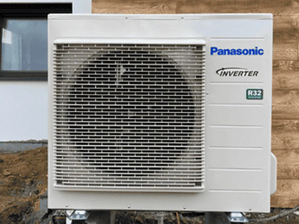 Pompa ciepła, Turza Śląska: Jednostka zewnętrzna Panasonic Inverter R32 (jeden wentylator) przy ścianie z okładziną drewnopodobną
